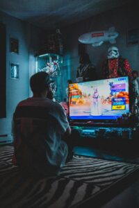 A young man engrossed in a video game in a cozy, decorated room, ideal for gamers.